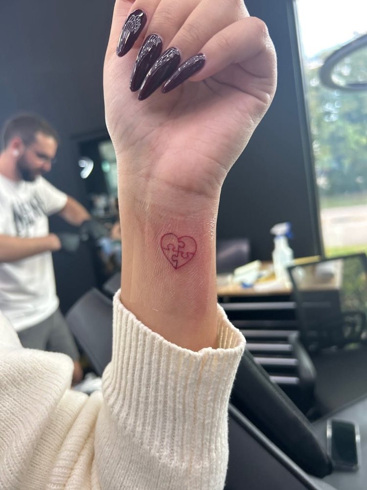 Micro red heart tattoo on the wrist